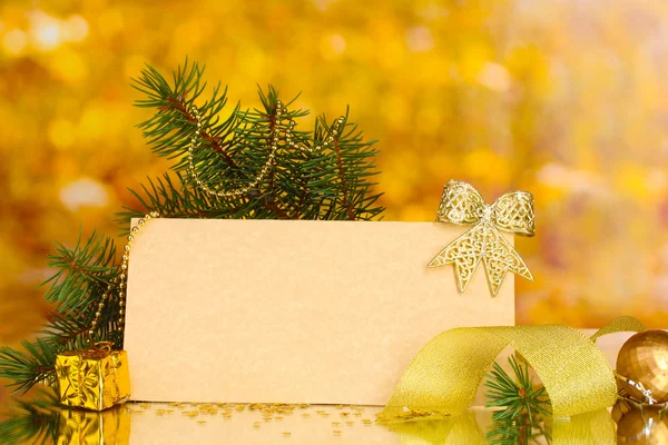 Cartolina bianca, palline di Natale e abete su sfondo giallo — Foto Stock