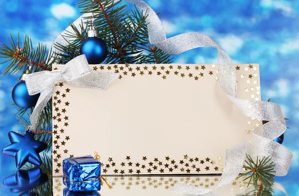 Cartolina bianca, palline di Natale e abete su sfondo blu — Foto Stock