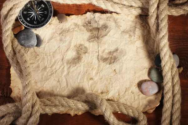 Старая бумага, компас и веревка на деревянном столе — стоковое фото