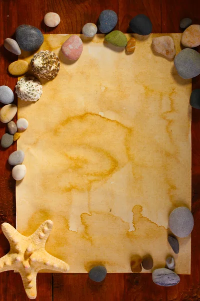 Papel velho, estrelas do mar e pedras na mesa de madeira — Fotografia de Stock