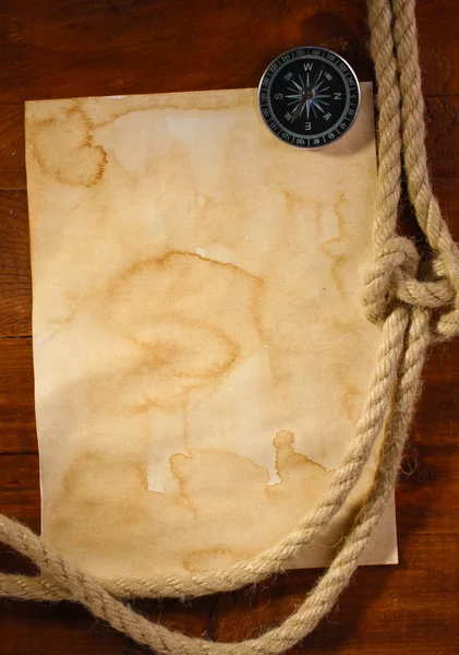 Gamla papper, kompass och rep på ett träbord — Stockfoto