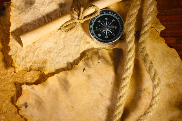 Gamla papper, kompass och rep på ett träbord — Stockfoto