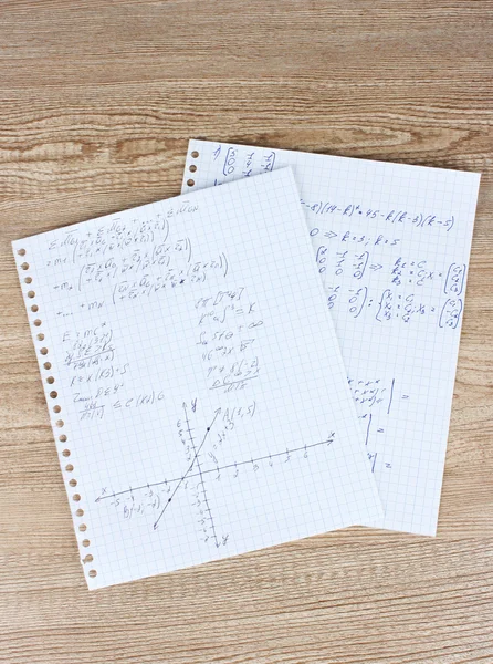 Matematica, fisica e geometria sulla pagina dei quaderni su un tavolo di legno — Foto Stock