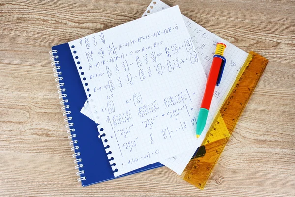 Math on copybook page on a wooden table — Stock Photo, Image