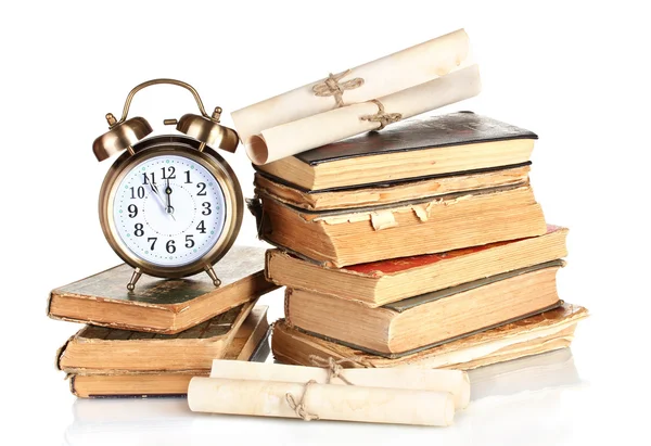 Mucchio di vecchi libri con orologio e scorrimento isolato su bianco — Foto Stock