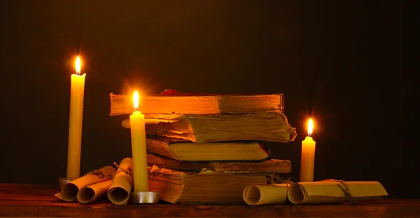 Σωρό των παλαιών βιβλίων με κερί και κύλισης στο σκοτάδι — Φωτογραφία Αρχείου