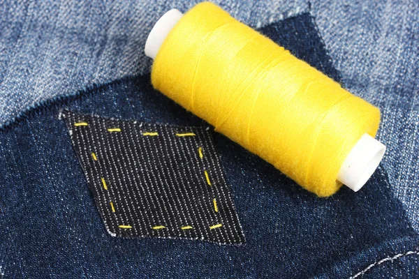 Rhomb-shaped patch on jeans with threads closeup — Stock Photo, Image