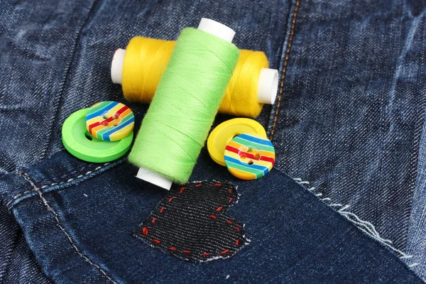 Heart-shaped patch on jeans with threads and buttons closeup — Stock Photo, Image