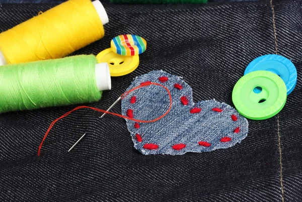 Parche en forma de corazón en jeans con hilos y botones de primer plano —  Fotos de Stock