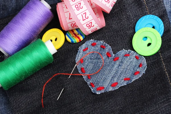 Parche en forma de corazón en jeans con hilos y botones de primer plano — Foto de Stock