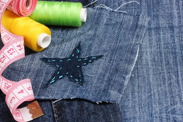 W kształcie gwiazdy patcha na dżinsy z zbliżenie nici i przyciski — Zdjęcie stockowe