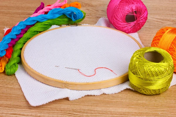 stock image The embroidery hoop with canvas and bright sewing threads for embroidery in