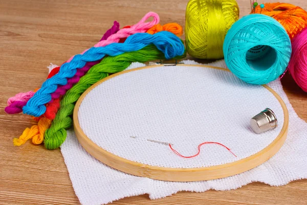 stock image The embroidery hoop with canvas and bright sewing threads for embroidery in