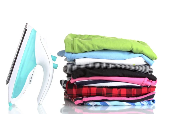 Montón de ropa colorida y plancha eléctrica aislada en blanco — Foto de Stock