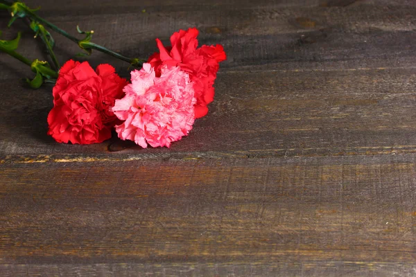木製の背景にカーネーションの花束 — ストック写真