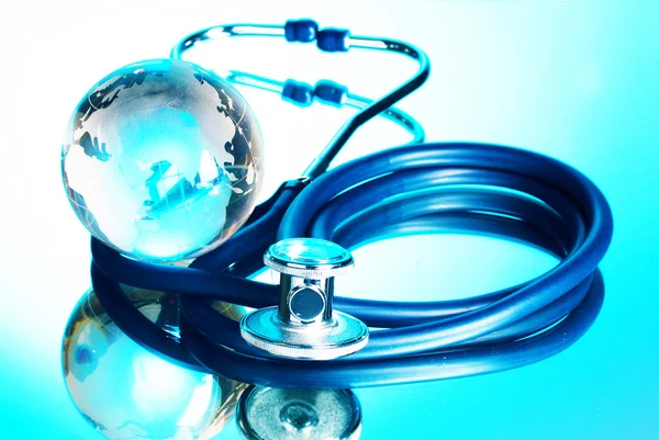 Globe and stethoscope on blue background — Stock Photo, Image