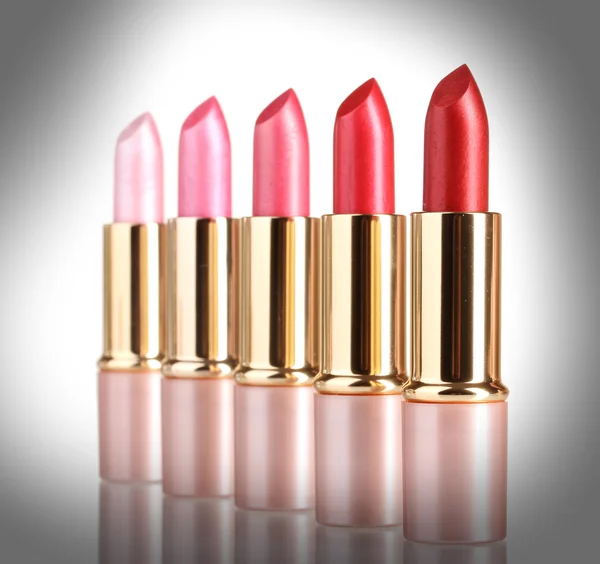 Beautiful lipsticks on grey background — Stock Photo, Image