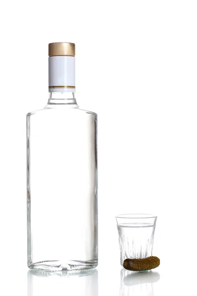 Пляшка горілки та келиха з огірком ізольовані на білому — стокове фото
