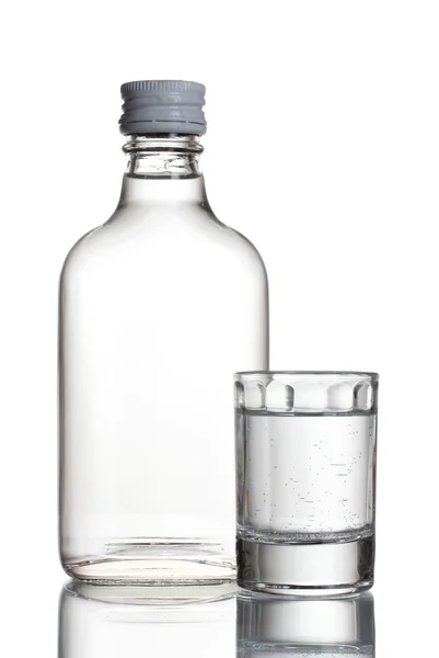 Пляшка горілки та келиха ізольовані на білому — стокове фото