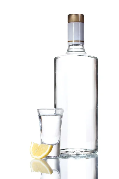 Bir şişe votka ve üzerinde beyaz izole limon ile şenlikli — Stok fotoğraf