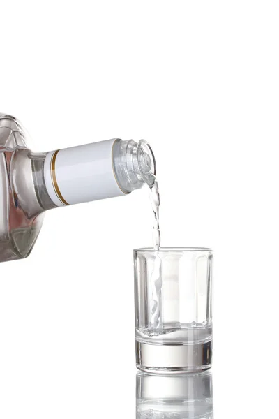 Vodka versé dans un verre isolé sur blanc — Photo