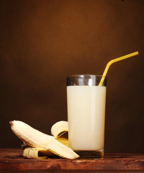 Succo di banana con banane su marrone — Foto Stock