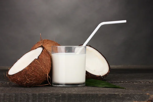 Kokosmelk en kokosnoot op grijs — Stockfoto