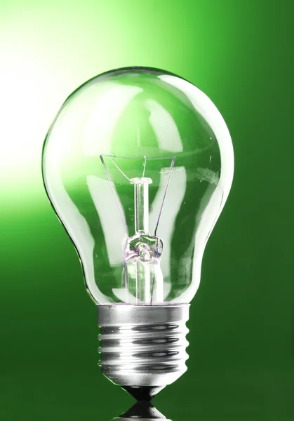 Лампочка на зеленому фоні — стокове фото
