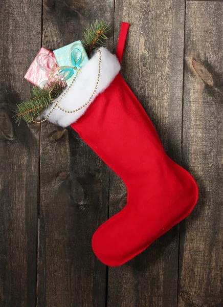 Kerstsok met geschenken op houten achtergrond — Stockfoto
