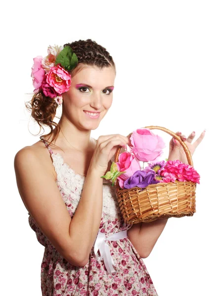 Menina bonita com flores em seu cabelo e com uma cesta de flores isolat — Fotografia de Stock