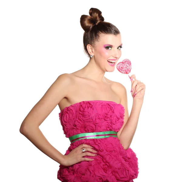 Fiatal lány, mint egy baba ruhák rózsaszín szív alakú cukorkát elszigetelt — Stock Fotó