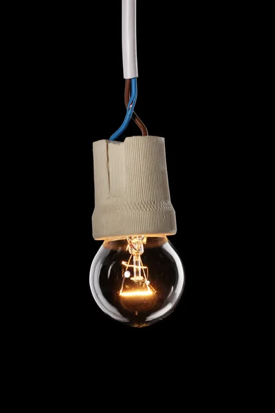 Uma lâmpada acesa no fundo preto — Fotografia de Stock