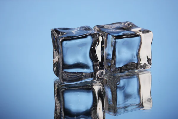 Кубики льда на синем фоне — стоковое фото