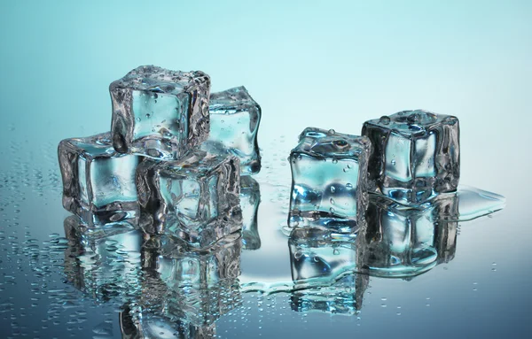 Smeltende ijsblokjes op blauwe achtergrond — Stockfoto