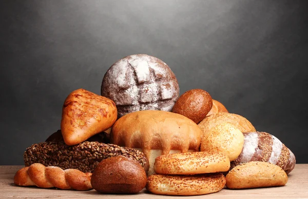 Výborný chléb na dřevěný stůl na šedém pozadí — Stock fotografie