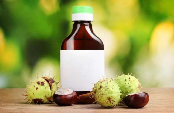 栗と緑の背景に木製のテーブルの上の医学の瓶 — ストック写真
