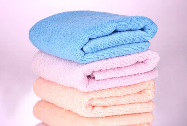 Три полотенца на розовом фоне — стоковое фото