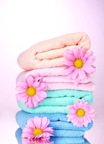 タオルとピンクの背景の美しい花 — ストック写真