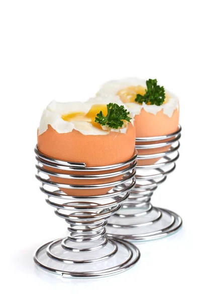 Boiled eggs in metal stands and parsley isolated on white — Stock Photo, Image