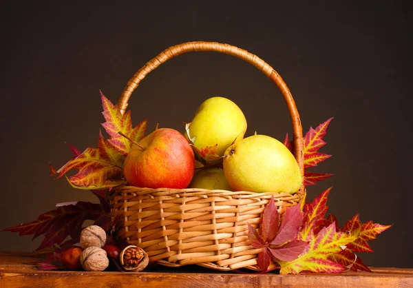 Piękna jesień zbiorów w kosz i liści na brązowym tle — Zdjęcie stockowe