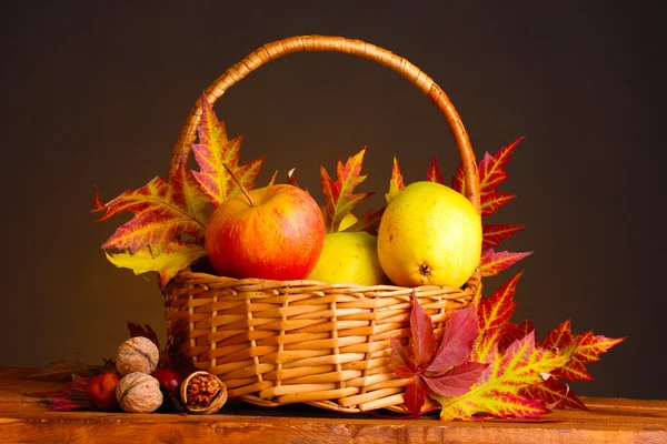 Vackra höstens skörd i korg och blad på brun bakgrund — Stockfoto