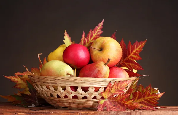 Bela colheita de outono em cesta e folhas no fundo marrom — Fotografia de Stock
