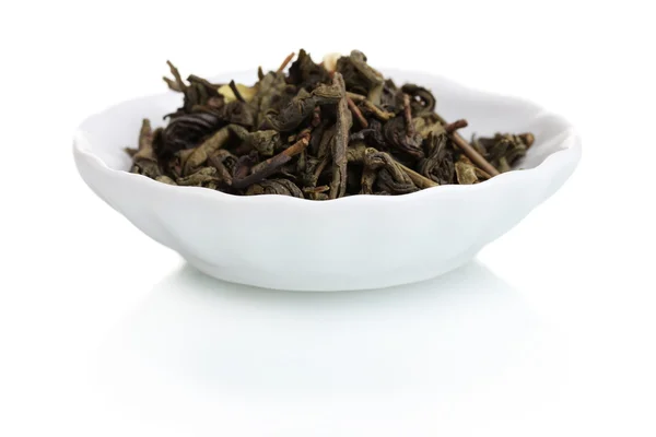 Зелене сухе листя чаю в тарілці ізольоване на білому — стокове фото