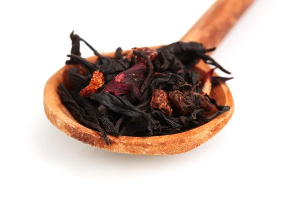 Schwarze Früchte trockene Teeblätter in Holzlöffel isoliert auf weiß — Stockfoto
