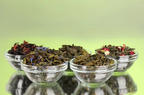 Différents types de thé sec vert et noir sur fond vert — Photo