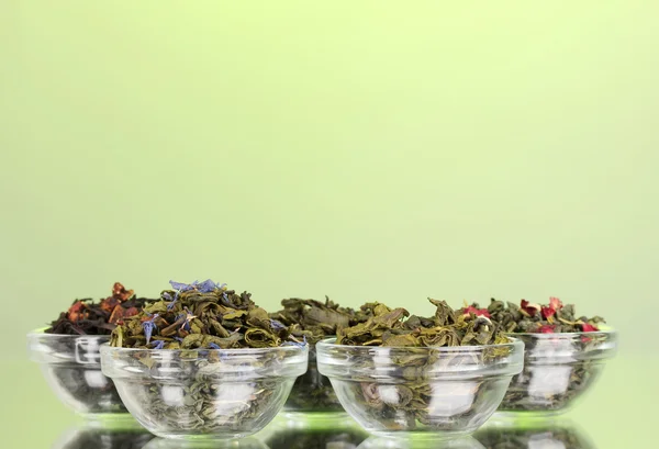 Différents types de thé sec vert et noir sur fond vert — Photo