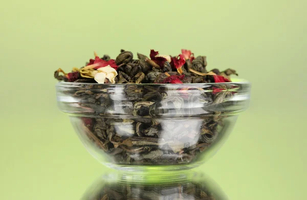 Farklı türlerdeki yeşil ve siyah çay yeşil zemin üzerine kuru — Stok fotoğraf