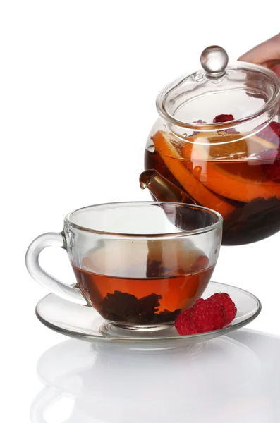 Glass teapot pouring black tea into cup isolated on white — Stock Photo, Image