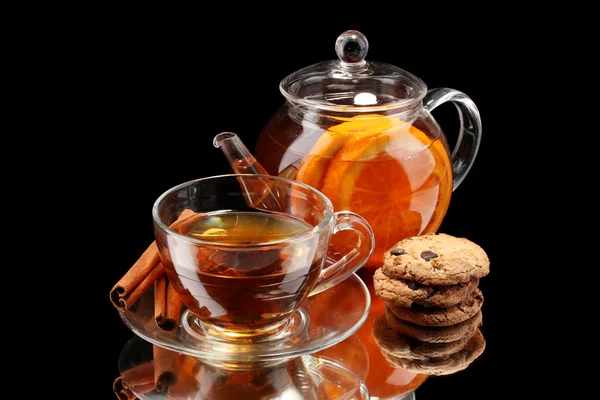 Tetera y taza de vidrio con té de fruta negra y galletas aisladas en blanco —  Fotos de Stock