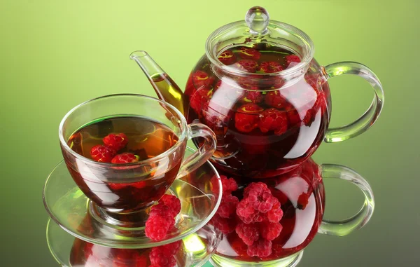 Tè al lampone alla frutta nera in teiera di vetro e tazza su sfondo verde — Foto Stock